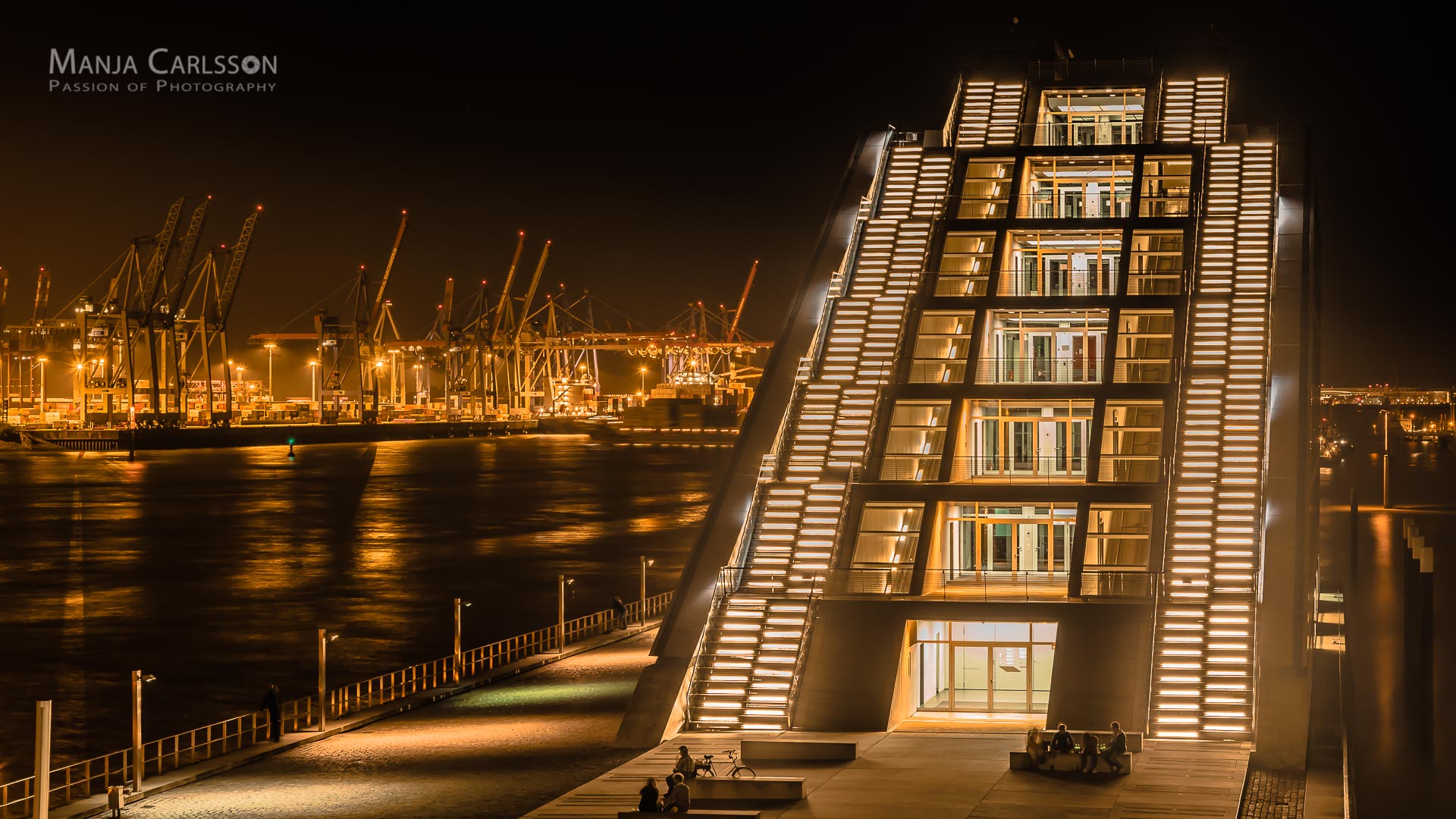 Dockland Blick auf den Eingang mit den beleuchteten Treppen und dem Hamburger Containerhafen 