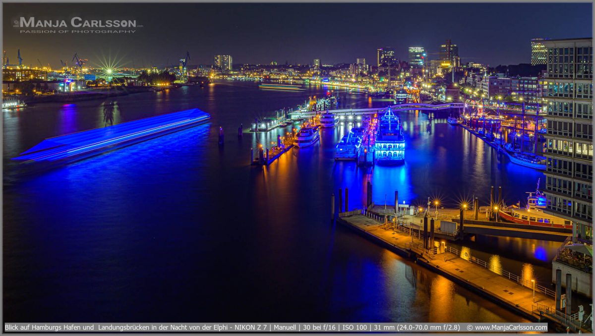 Blick auf Hamburgs Hafen und Landungsbrücken in der Nacht von der Elphi