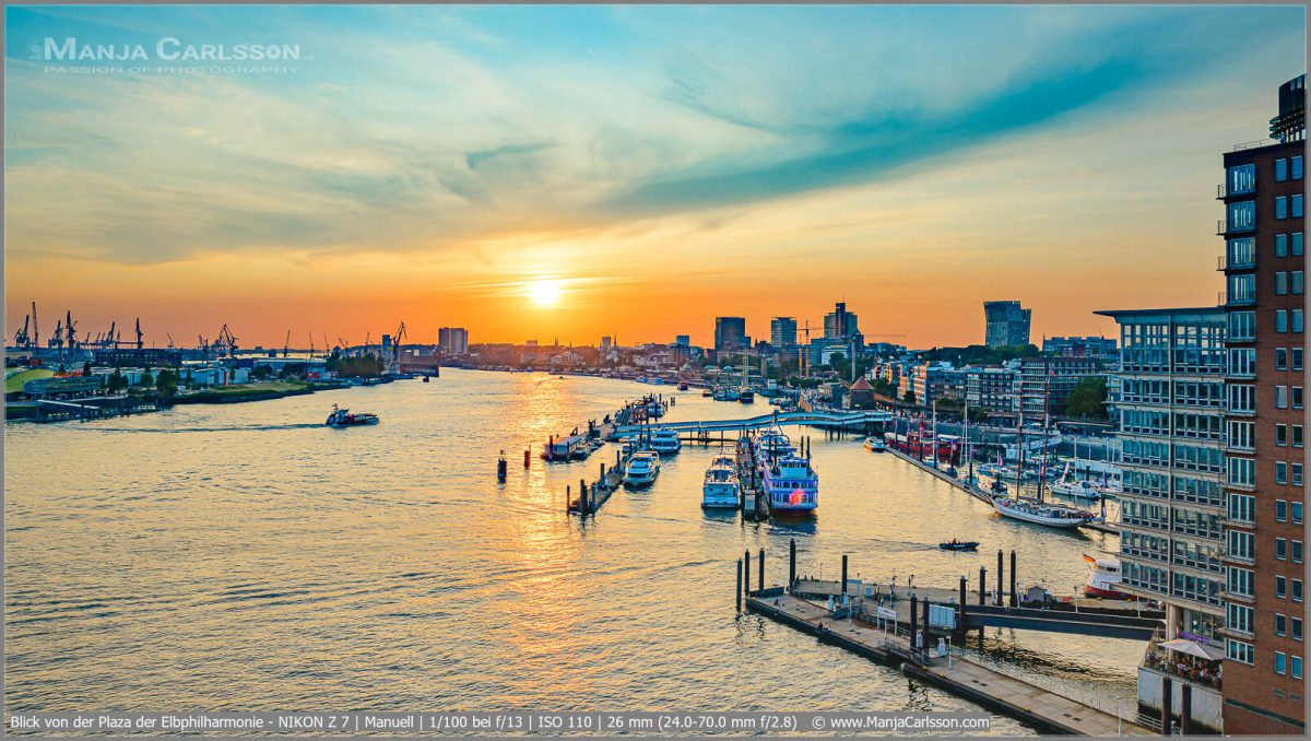 Blick von der Plaza der Elbphilharmonie zum Sonnenuntergang auf den Hamburger Hafen und den Landungsbrücken